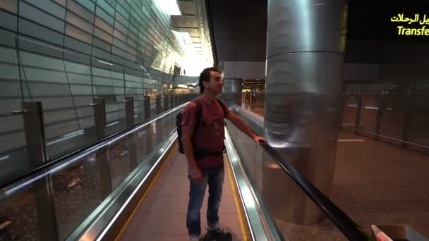 Mann hebt auf Rolltreppe am Flughafenterminal, Passagier schaut sich aufgeregt um, Reisekonzept, inspirierende Menschen, positive Einstellung — Stockvideo