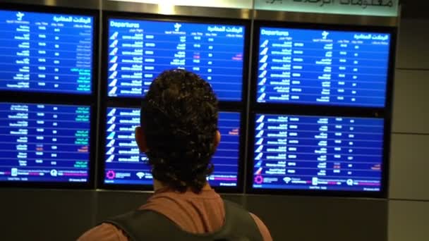 Pasażera człowiek patrząc na rozkład jazdy deska ekran w terminalu lotniska, międzynarodowego lotu, człowiek biznesu podróżuje za granicą koncepcja — Wideo stockowe