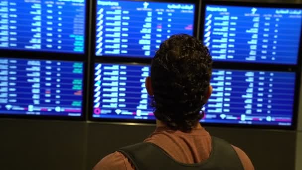 Людина пасажир дивиться на екран розкладу на борту терміналу аеропорту, міжнародний рейс, бізнесмен виїжджає за кордон концепція — стокове відео