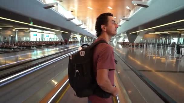 Sollevamento uomo sulla scala mobile al terminal dell'aeroporto, passeggero che si guarda intorno eccitato, concetto di viaggio, persone di ispirazione, atteggiamento positivo — Video Stock