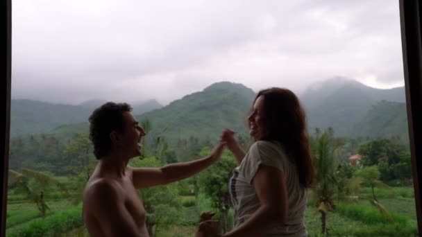 Divertida pareja feliz bailando en el balcón con hermosa vista a la montaña, personas enamoradas, disfrutar de su vida, emociones, impresiones, inspiraciones — Vídeo de stock