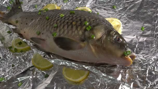 Карп рыбы на фольге маринованных с овощами и лимоном здоровой пищи хороший рацион вкусный омега 3 ждет гриль в ресторане поливая специи на него — стоковое видео