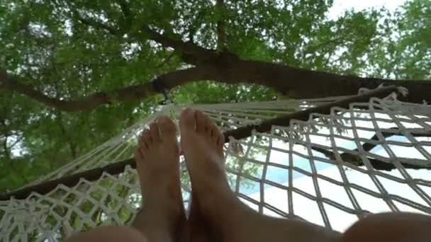 Hombre cansado perezoso que relaja en la hamaca en un día hermoso en la playa, concepto de las vacaciones del recorrido — Vídeo de stock