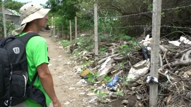 Mannstouristen, die Slums mit Müllhalden voller Armut betrachten, reisen nach Asien, Elend, zerstörte Gegend, schlechte Lebensbedingungen Straßen — Stockvideo