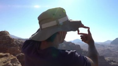 Adamın biri elinde fotoğraf çerçevesi, güzel dağ manzarası, ilham verici, seyahat konsepti.