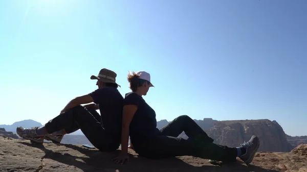 Pár turistů sedících na okraji hor, láska, přátelství, partnerský koncept, dobrodružství — Stock fotografie