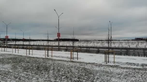 Biały samochód jadący pustą zimową drogą śnieżną, strzał z powietrza — Wideo stockowe