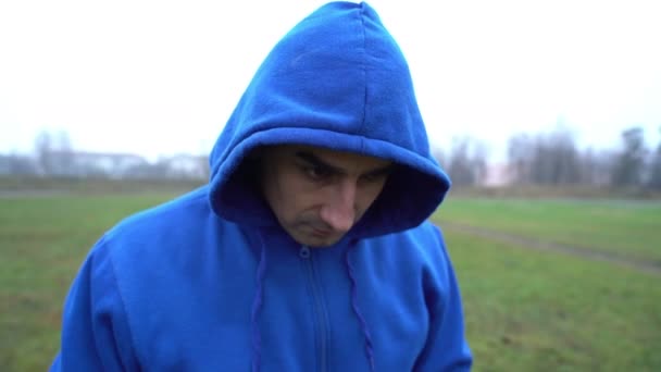 Problém se vztekem, muž v kapuci vypadá agresivně, snaží se někoho vyprovokovat k boji, hněvu — Stock video