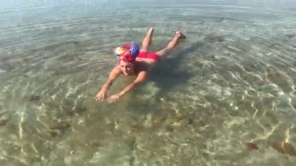 Mulher nadando em um mar morto, engraçado, deitado de costas, tiros de viagem no telefone móvel — Vídeo de Stock