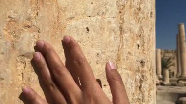 female hand touching acient ruins of old roman city, travel concept, history architecture