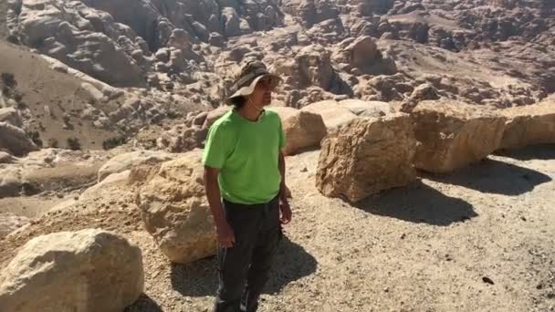 Muž turista, stojící na poušti žluté hory Jordanu, s odpočinkem rozhlíží — Stock video
