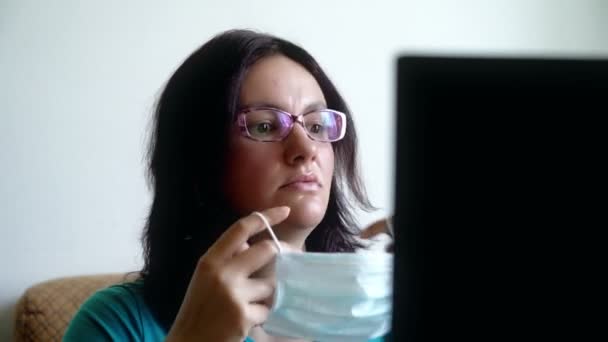 Vrouw gezet op masker, het lezen van nieuwe over pandemie van het virus op laptop, kijkt bang geschokt en — Stockvideo