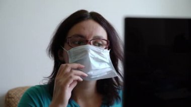 Kadın, dizüstü bilgisayardaki virüs pandemisi haberini okuduktan sonra maskeyi fırlatıp atmış.