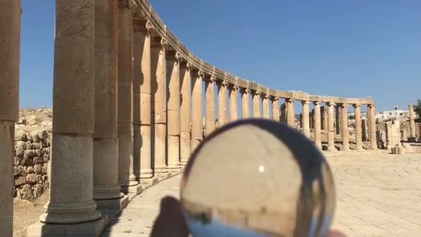 Bola de cristal reflexión contra ruinas antiguas de la ciudad romana, columnas, celebración de la mano — Vídeo de stock