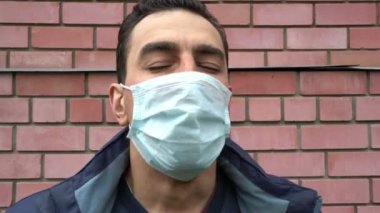 Tıbbi maskeli adam nefes alamaz, boğulamaz, boğulamaz, hasta, ağır öksürük, nefessiz, acı çekemez.