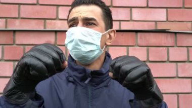 Maskeli adam boks eldiveni giyiyor, çıldırıyor, kendini görünmez tehditten korumaya çalışıyor.