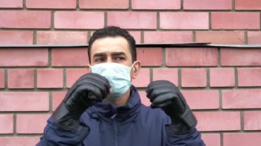 Maskeli adam boks eldiveni giyiyor, çıldırıyor, kendini görünmez tehditten korumaya çalışıyor.