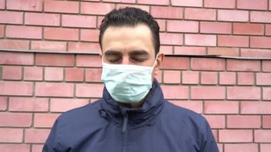 Maskeli üzgün adam tek başına duruyor, gözleri kapalı, sosyal uzaklık, kendini soyutlama, karantina konsepti