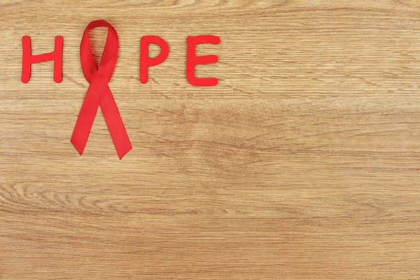 Onkolojik Hastalık Konsepti Umut Kelimesi Kırmızı Kurdeleyle Yazılmış Ahşap Zemin — Stok fotoğraf