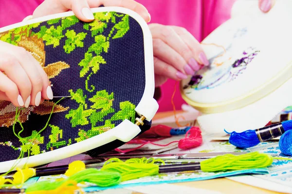 Kadınlar birlikte nakış işliyor. İplikleri, resimleri, iğneleri olan bir iş yeri..