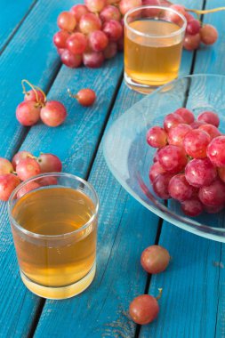 Bardak taze üzüm suyu ve pembe üzüm demet