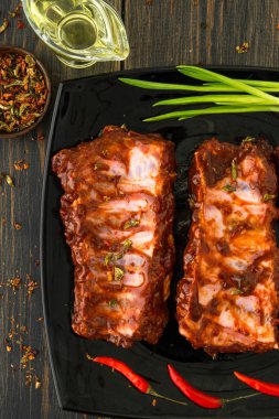 Kırmızı biber ile sulu füme kaburga bir siyah cam tabak, 