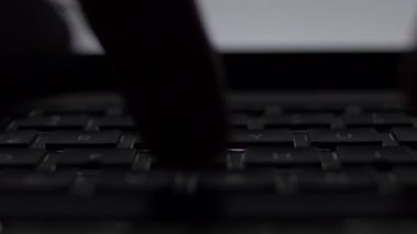 Yakın öne erkek el laptop sırt klavye ile karanlık odada yazarak.