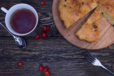 Ev yapımı pasta ve fincan çay kuşburnu çilek ile ve grunge ahşap arka plan üstten görünüm üzerinde çatal