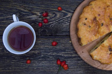 Ev yapımı pasta ve fincan çay kuşburnu ile çilek grunge ahşap arka plan Üstten Görünüm