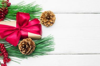 Hediye kutusu ile koni Beyaz ahşap antika arka plan üzerinde kırmızı şerit yay ve şube Noel ağacı ile