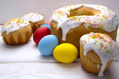 Paskalya yumurtaları ve beyaz ahşap masa üzerinde farklı Paskalya kek