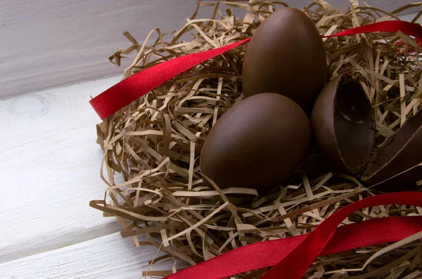 Huevos Chocolate Nido Con Cinta Roja Sobre Fondo Madera Blanca —  Fotos de Stock