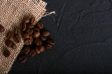 Kahve çekirdekleri karanlık çimento zemin üzerine çuval bezi kumaş görünümü top