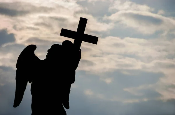 Silhouette angélique avec croix au coucher du soleil — Photo