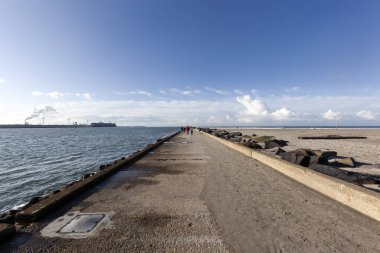 Meuse nehrinin rıhtımında Kuzey Denizi ve sağda plaj var.