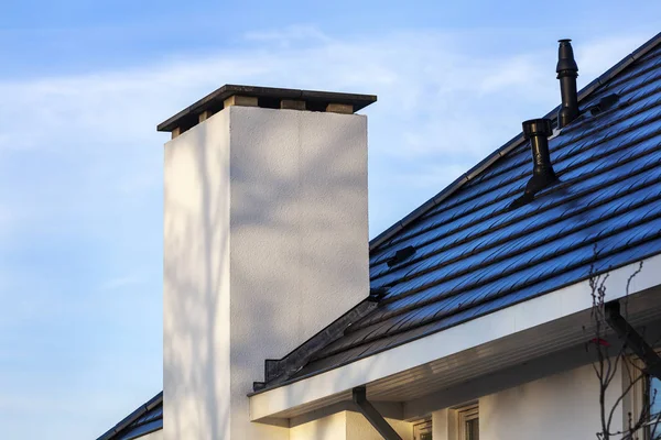 Contemporary white chimney and a black tiled roof — Stock Photo, Image