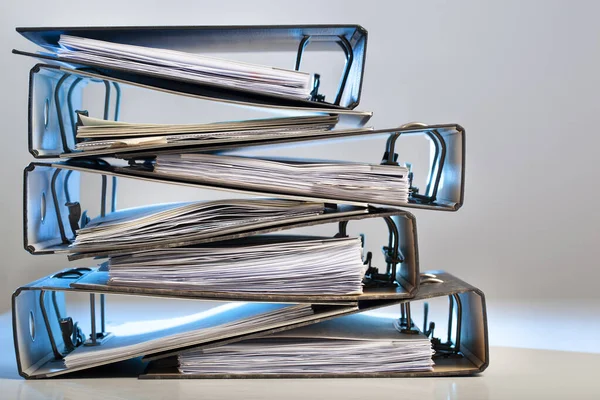 Stack of office folders with archived paperwork in red light