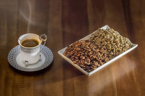 Białe filiżanka gorący kawa po turecku i ziarna kawy rozproszone — Zdjęcie stockowe