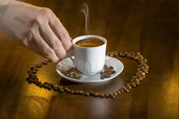 Białe filiżanka gorący kawa po turecku i ziarna kawy rozproszone — Zdjęcie stockowe