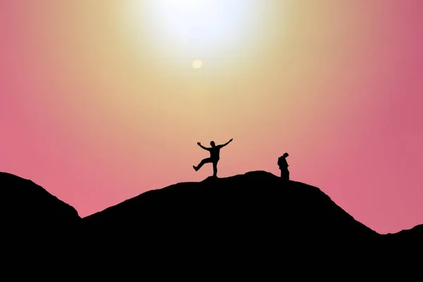 Silhouettes of people on mountains