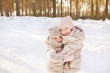 İki küçük kız kardeşi bir bej sıcak giysiler kış portresi