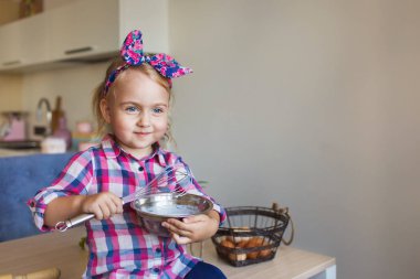 Kareli gömlekli sevimli küçük kız portresi bir mutfak bir krem kadar kamçı
