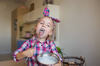 Küçük kız Kareli gömlekli kamçı ve evde bir krem yalıyor