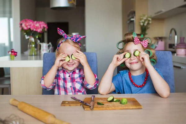 Duas irmãs tolas com um vegetal em uma cozinha — Fotografia de Stock