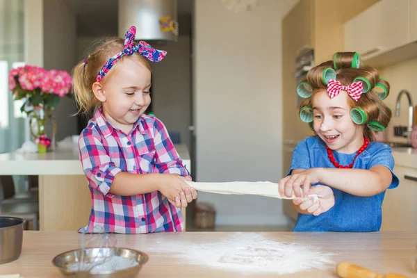 Le piccole sorelle divertenti giocano con una pasta su una cucina — Foto Stock