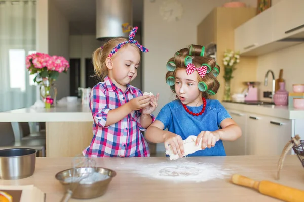 Sorelline divertenti scolpire un impasto su una cucina — Foto Stock