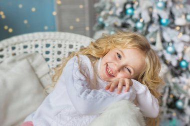 Küçük bir sandalye üzerinde Noel zamanında gülümseyen portresi