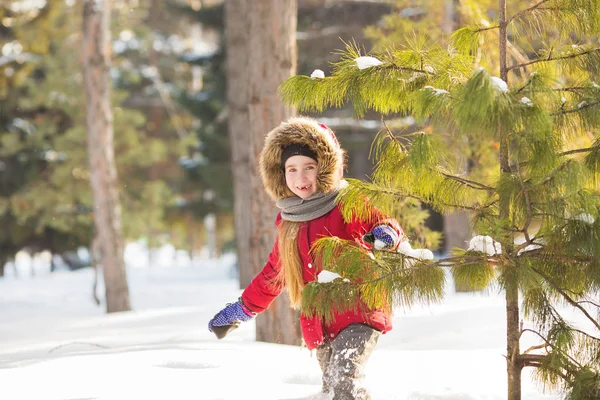 Petite fille en veste rouge marche volontiers dans la neige dans le bois — Photo