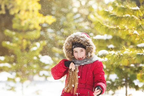 Ritratto di bambina in giacca rossa gioca con una neve in parco in inverno — Foto Stock