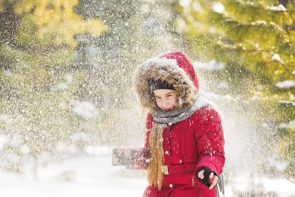 Couverture de neige une petite fille en veste rouge dans le parc en hiver — Photo
